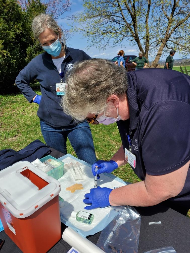 ​Judy Graham and Susan Ackerman prepare doses of vaccine.