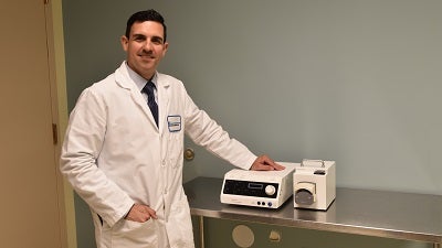 Dr. Ferrara poses with Bassett Medical Center’s radiofrequency thyroid ablation equipment in an outpatient clinic space. 