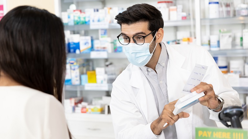 Pharmacist showing patient Narcan Nasal Spray