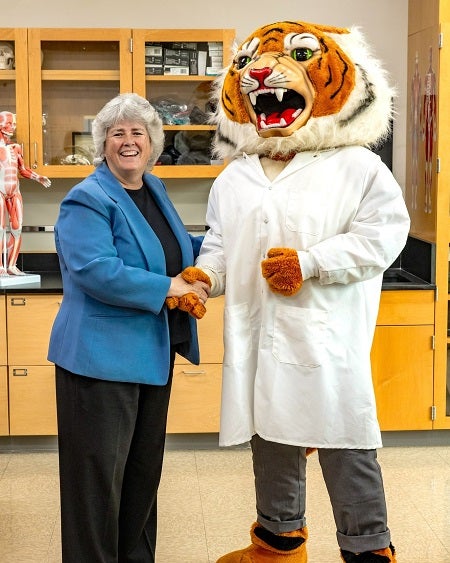 President of Maria College shaking hands and posing with SUNY Cobleskill's mascot