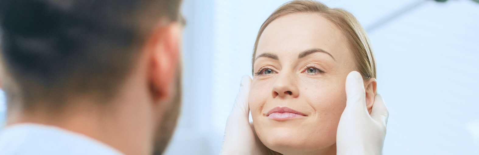 Plastic surgeon examining patient