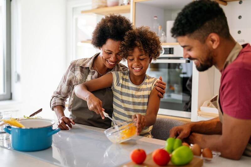 Happy family cooking healthy food together
