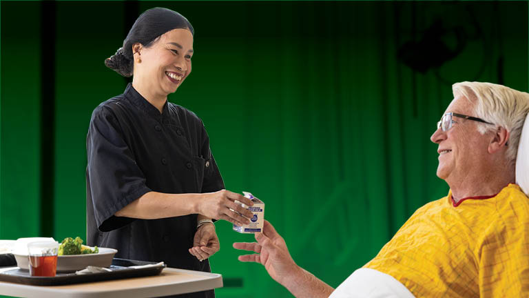 Bassett food service caregiver delivering food to a patient