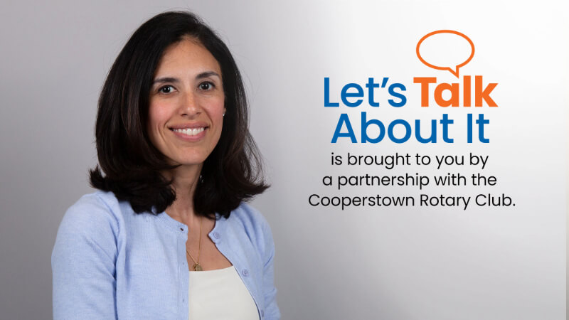 A photo of Dr. Nicole Betancourt, a woman with shoulder length hair, is next to text that reads "Let's Talk About It is brought to you by a partnership with the Cooperstown Rotary Club" 