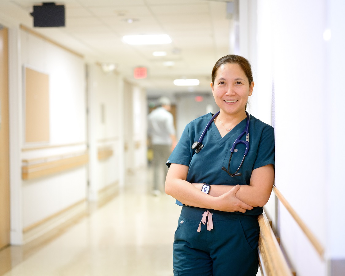 Bassett nurse leaning against a hospital wall