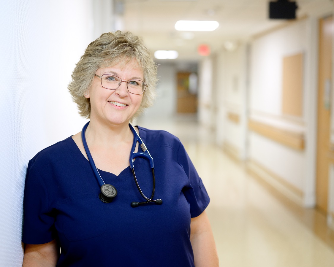 Bassett LPN leaning against a hospital wall