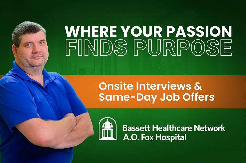Male Bassett housekeeping employee cmiling at the camera against a green background that reads: "where your passion finds purpose" and "onsite interviews & same-day job offers" with the A.O. Fox Logo