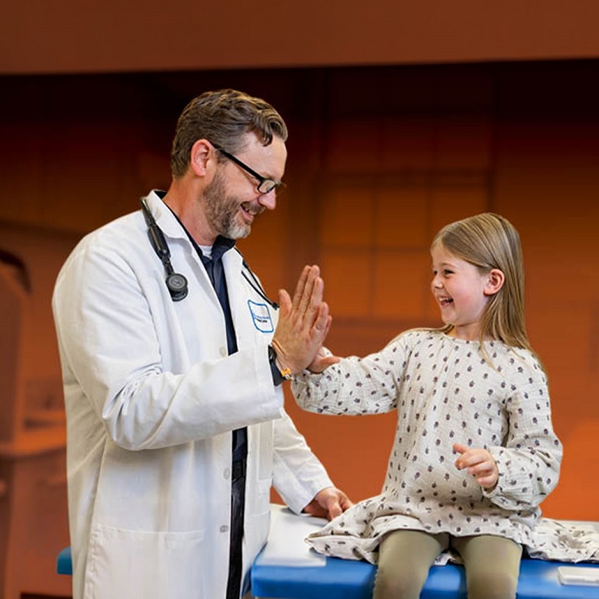 Bassett physician with child patient against an orange clinical background