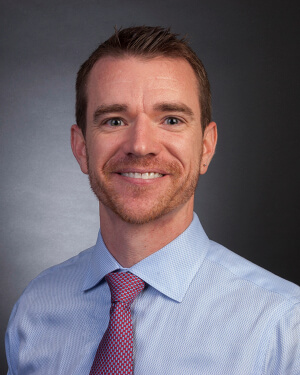 A man in a dress shirt and tie is photographed