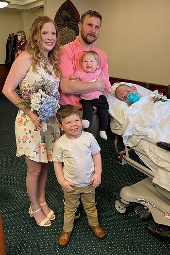 Morgan, Brad, and their 2 kids posing with Brad's father in the Bassett Medical Center Chapel